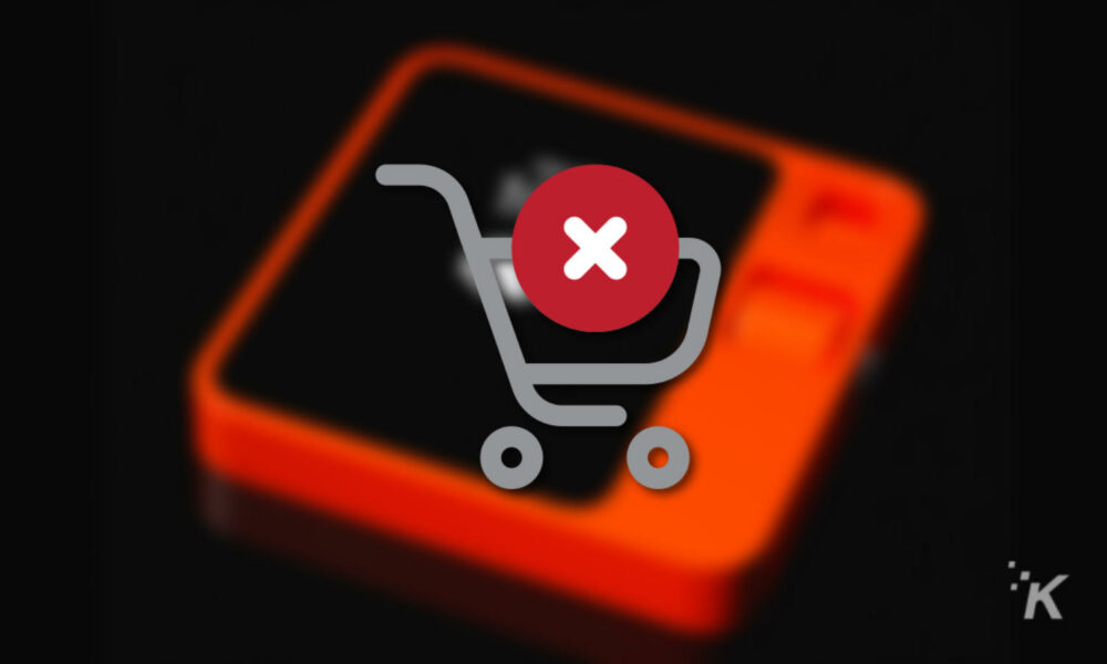 Red X over shopping cart on blurred rabbit r1 device in background