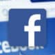 facebook logo with blurred facebook website in background