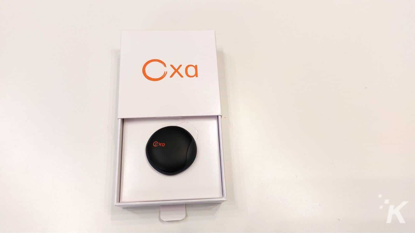 Oxa branded device in open packaging on white table.