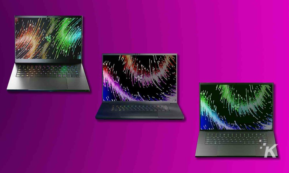 Three laptops with colorful screen savers on purple background.