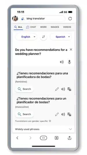 A person is using a translation tool to ask for recommendations for a wedding planner in both Spanish and English. Full Text: 11:11 all 5G (5) bing translator C Q ALL CHAT WORK IMAGES VIDEOS English Spanish Do you have recommendations for a X wedding planner? (0) ¢ ¿Tienes recomendaciones para una planificadora de bodas? (feminine) Q Search ¿Tienes recomendaciones para un planificador de bodas? (masculine) Q Search Translations are gender specific O Widely used phrases ...
