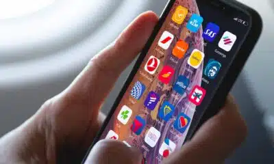hands holding a smartphone with airline apps displayed on it