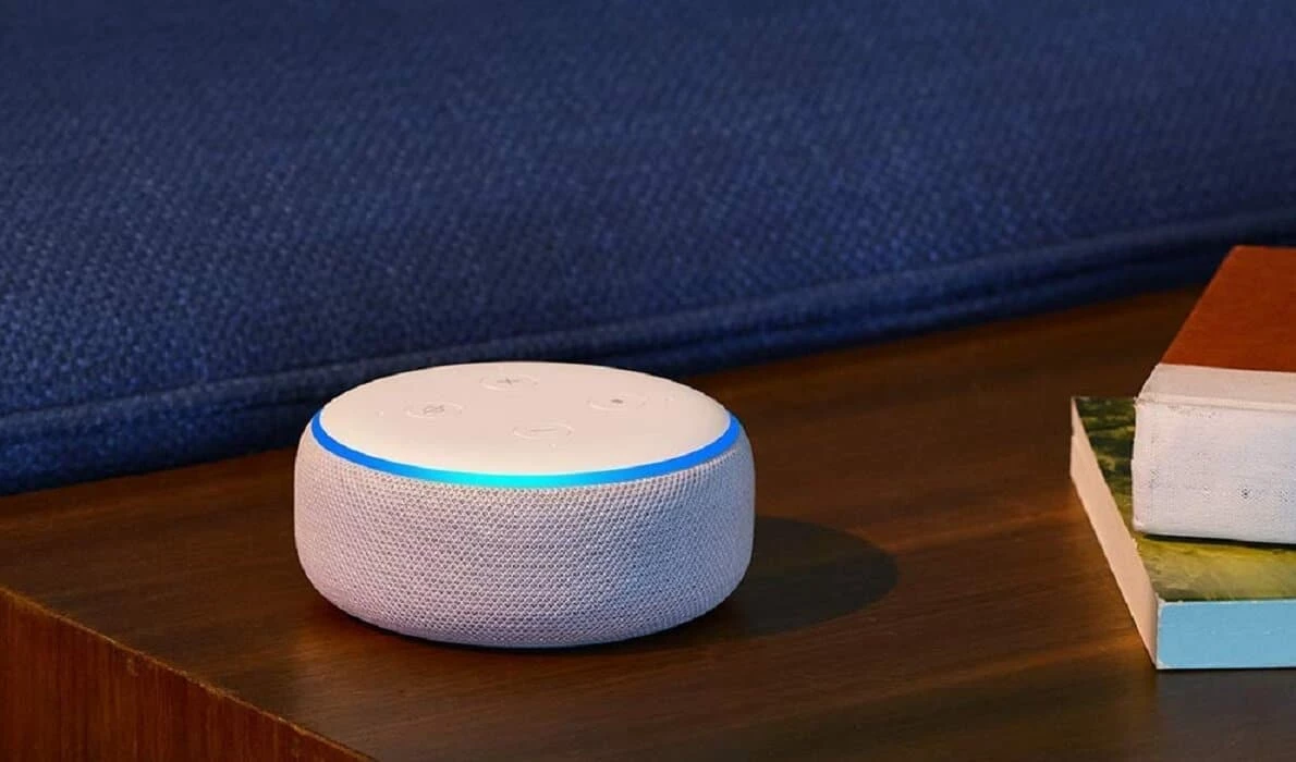 an amazon echo dot device with alexa against a blue background