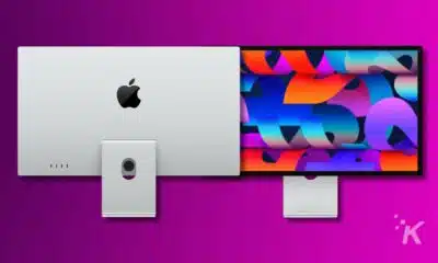 An Apple iMac with its back visible on the left and a colorful screen display of an Apple Pro Display XDR on the right against a purple background.