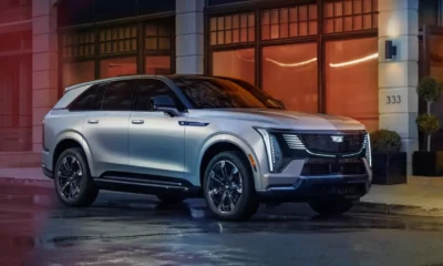 A silver car is parked in front of a building.