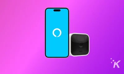 A mobile phone is displaying a Alexa App with Blink Camera on the background