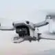 White mini 4K camera drone flying, soft background