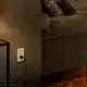 eve smart socket installed on a dark living room wall