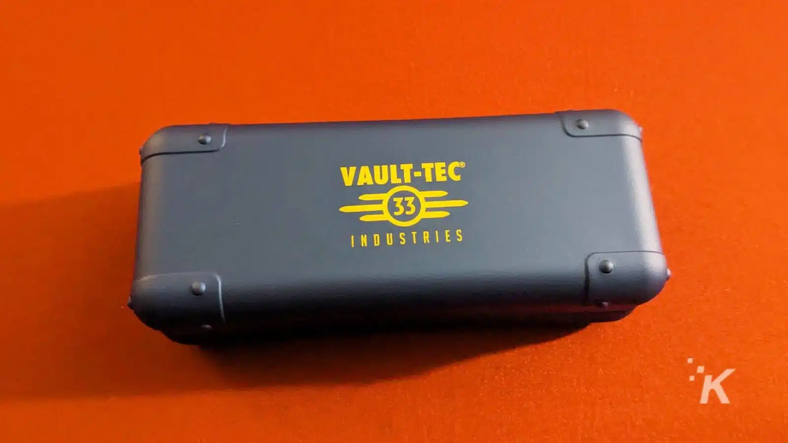 Vault-Tec branded case on orange background.