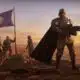 Futuristic soldiers with flag on Mars-like terrain.
