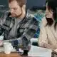 Two professionals collaborating on a laptop at office desk.