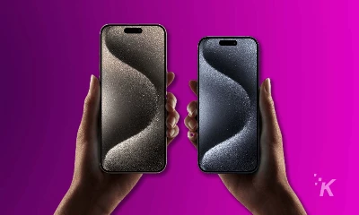 iPhone 15 in hands purple background