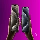 iPhone 15 in hands purple background