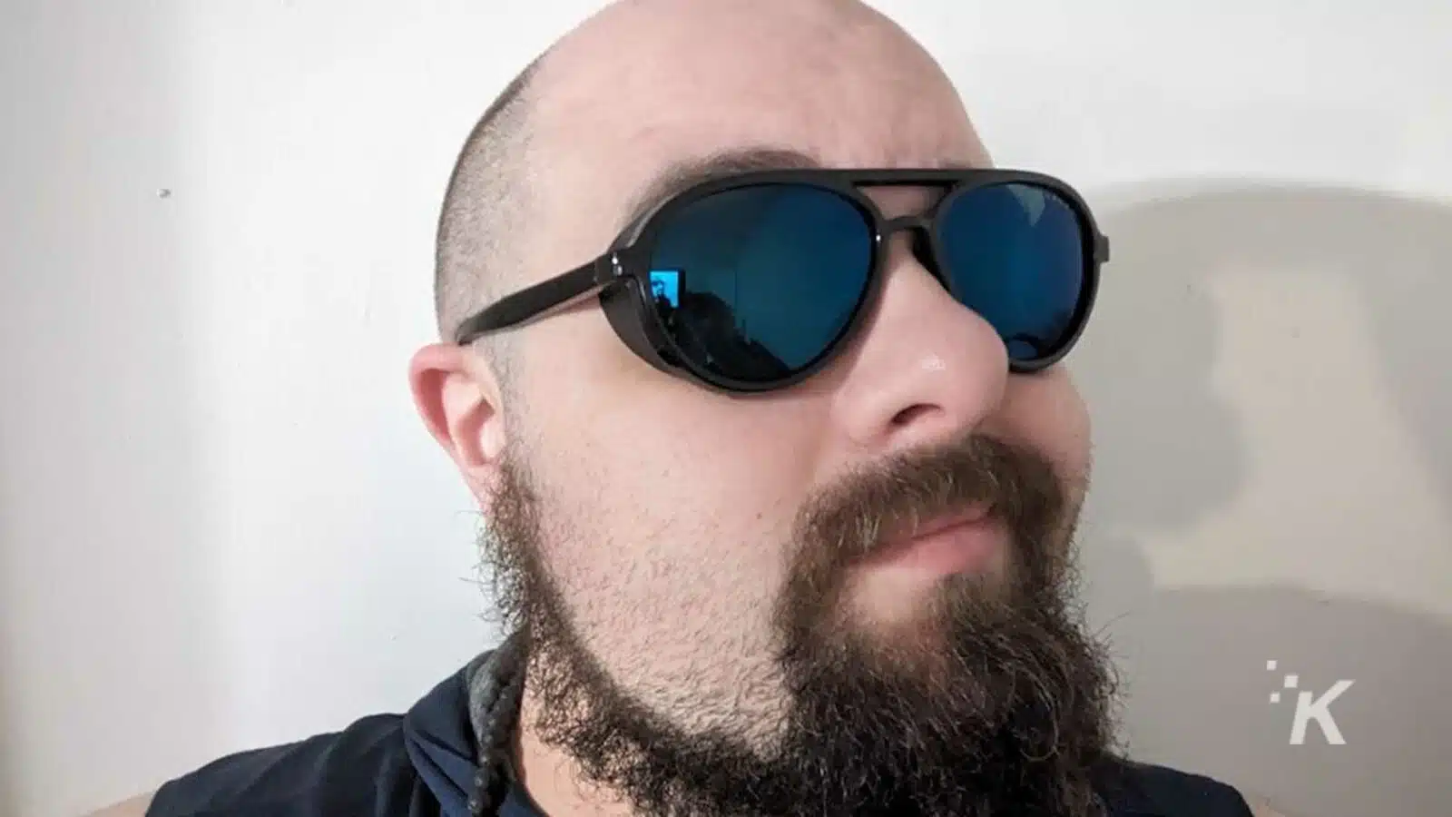 Bald man with beard wearing sunglasses.