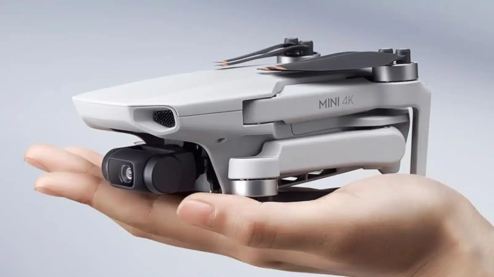 Compact 4K drone resting on human hand.