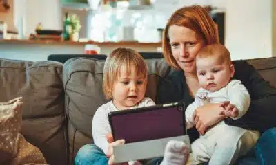 mother looking at a tablet with her children