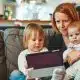 mother looking at a tablet with her children