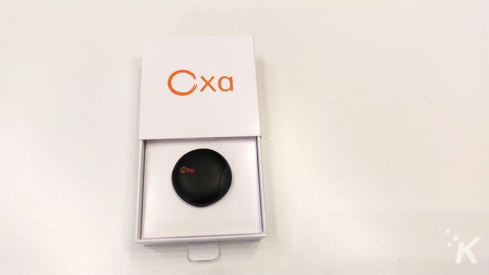 Oxa branded device in open packaging on white table.