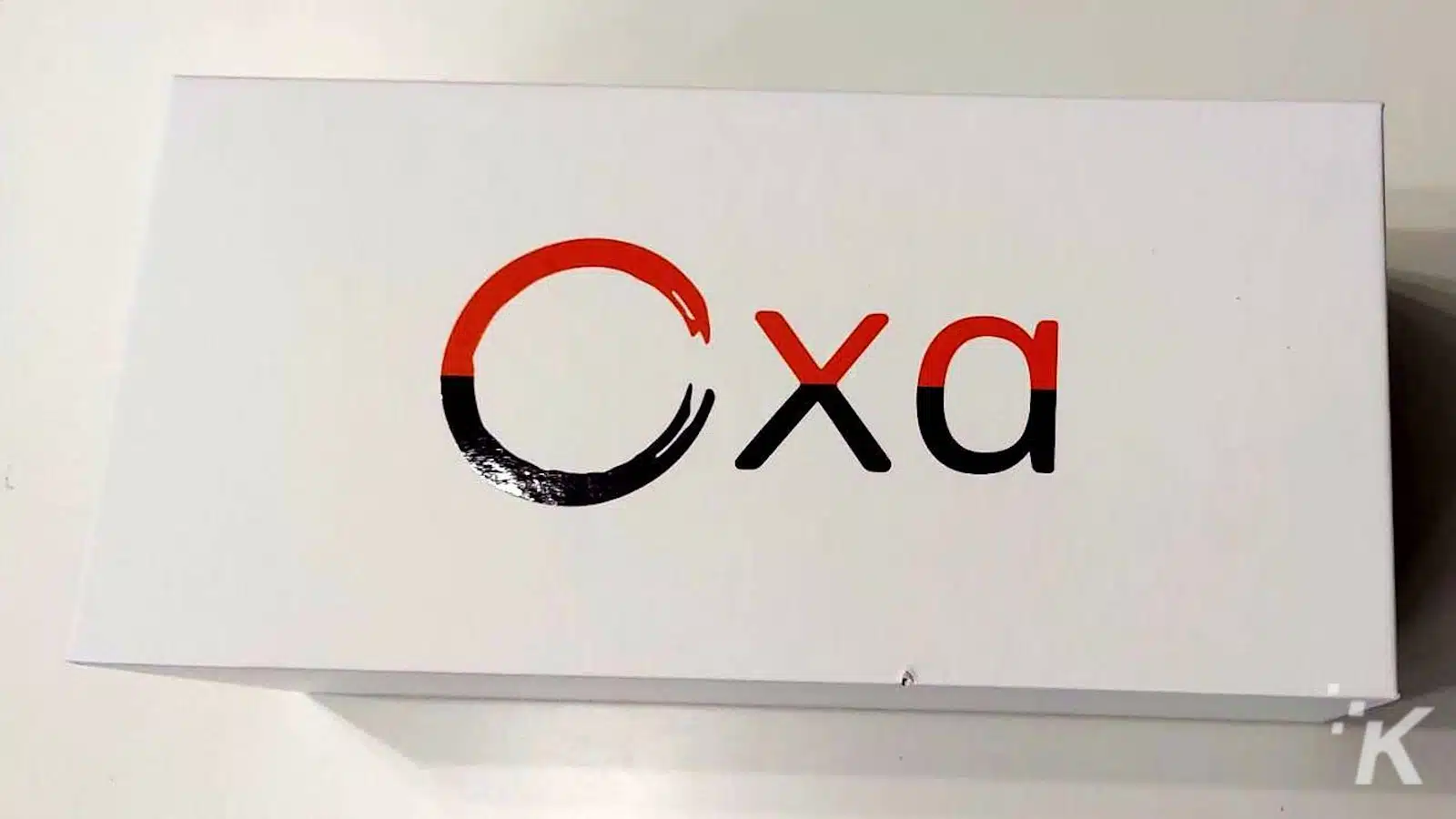 Logo with letters 'Cxa' in black and red.