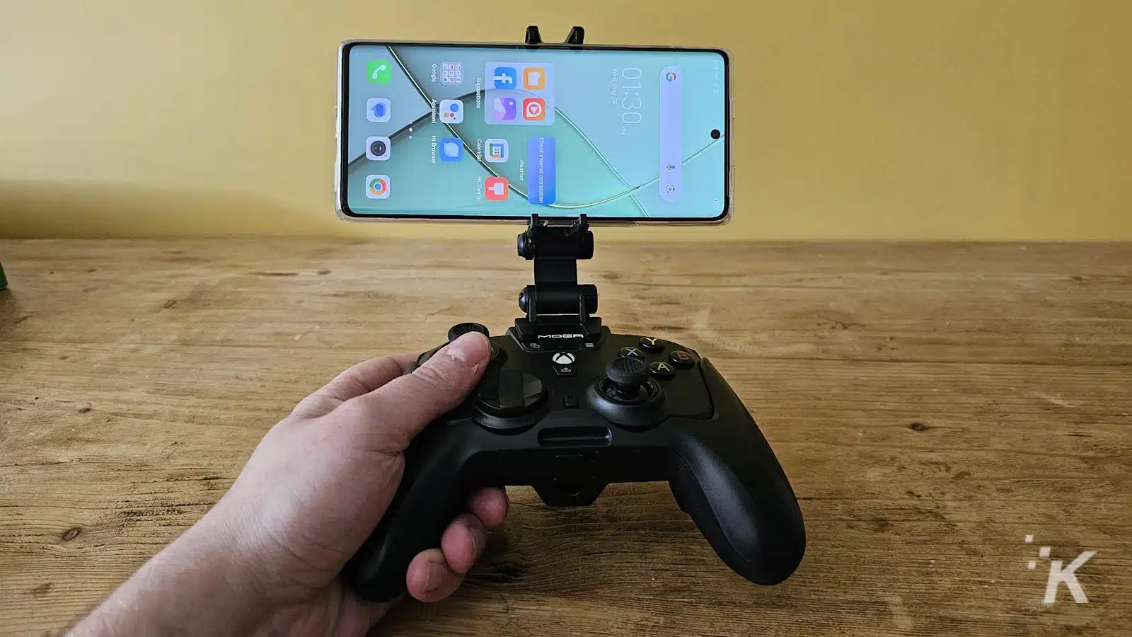Smartphone mounted on game controller for mobile gaming.