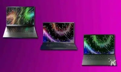 Three laptops with colorful screen savers on purple background.