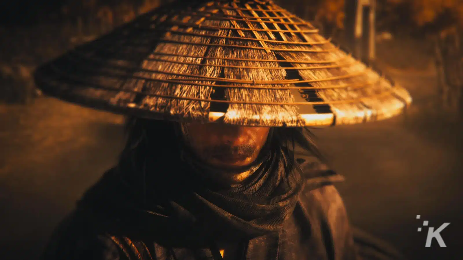 A person wearing a traditional conical Asian hat, partly obscuring their face, set against a warm, soft-focus background.