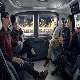 A group of people ride the train together.