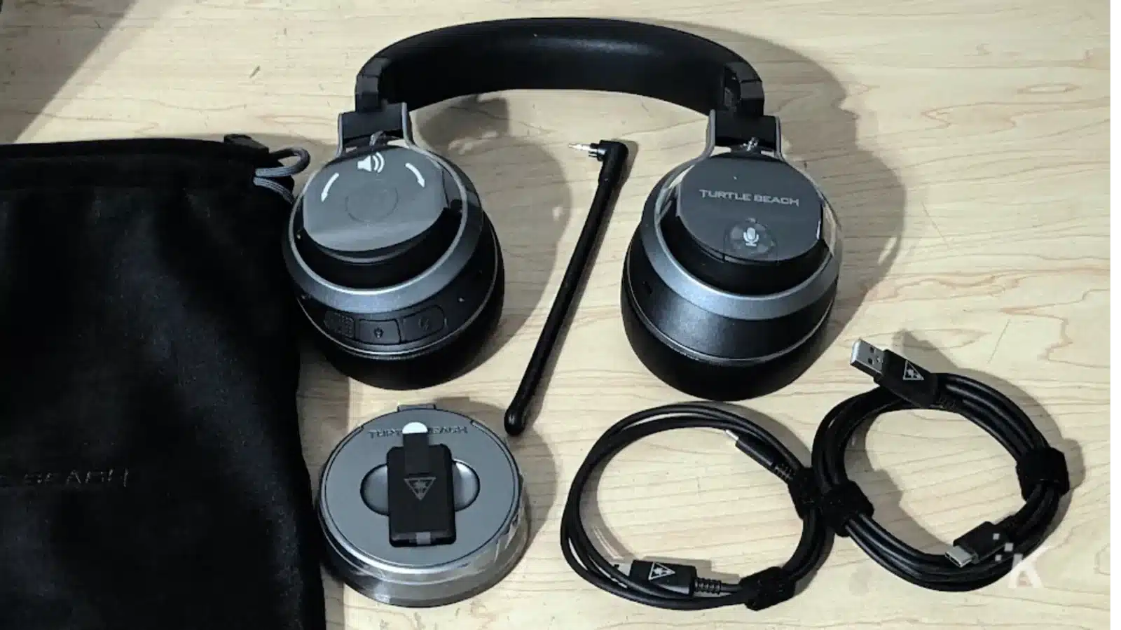 A black bag with a Turtle Beach AF headphone, camera, cable, and other everyday carry gadgets and accessories is strapped to the side.